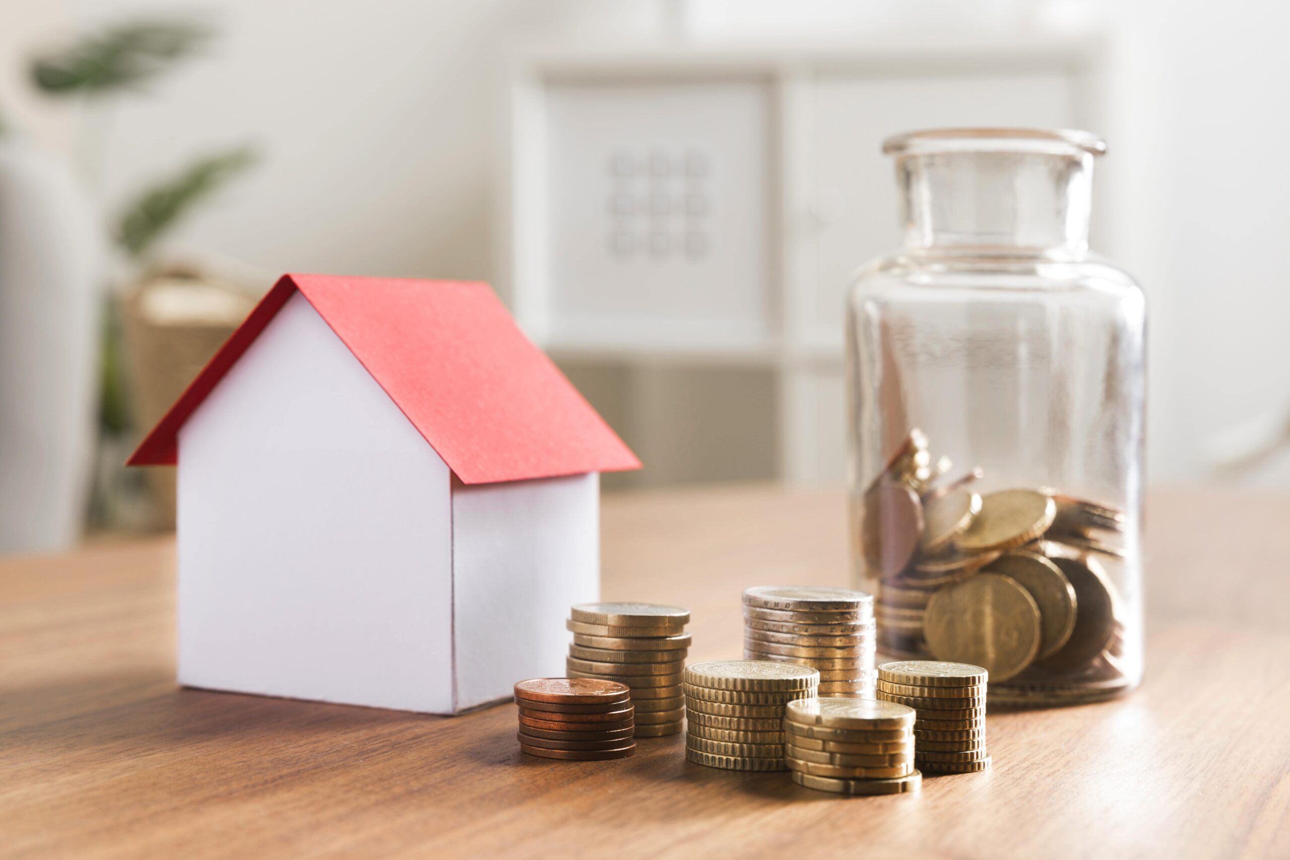 miniature-bank-with-coins-stacks-jar-beside-min